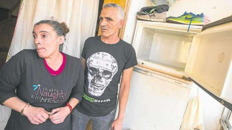 Sandra y Antonio posan junto a la nevera de casa. La tienen arrimada en la terraza del piso donde viven. No tienen luz desde hace dos años (Foto TA)